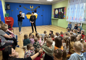 Na zdjęciu pan górnik, który opowiada dzieciom o swojej pracy, w tle widać dzieci słuchające z zaciekawieniem