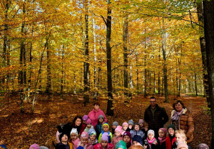 Na zdjęciu dzieci wraz z paniami i panem leśniczym podczas wycieczce po lesie