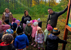 Na zdjęciu Pan leśniczy opowiada dzieciom ciekawostki o zwierzętach leśnych, w tle pani Renata i Pani Kasia