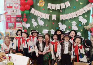 Na zdjęciu chłopcy wraz z Panią Kasią i Dominiką na tle dekoracji ubrani w stroje góralskie