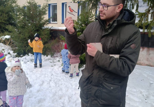 Na zdjęciu Pan leśniczy trzyma w dłoni sylwetę ptaka, zimującego w Polsce