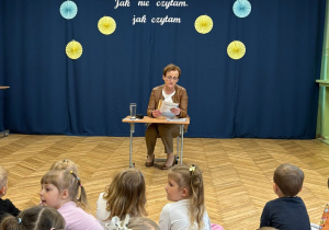 na zdjęciu gość specjalny, ktory czyta dzieciom bajkę, w tle widać zasłuchane dzieci