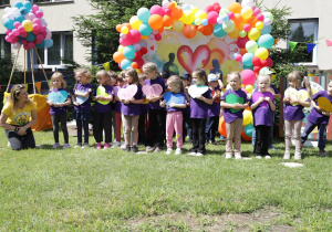 na zdjęciu dzieci z grupy Bratki podczas występy dla rodziców, ubrani w fioletowe podkoszulki